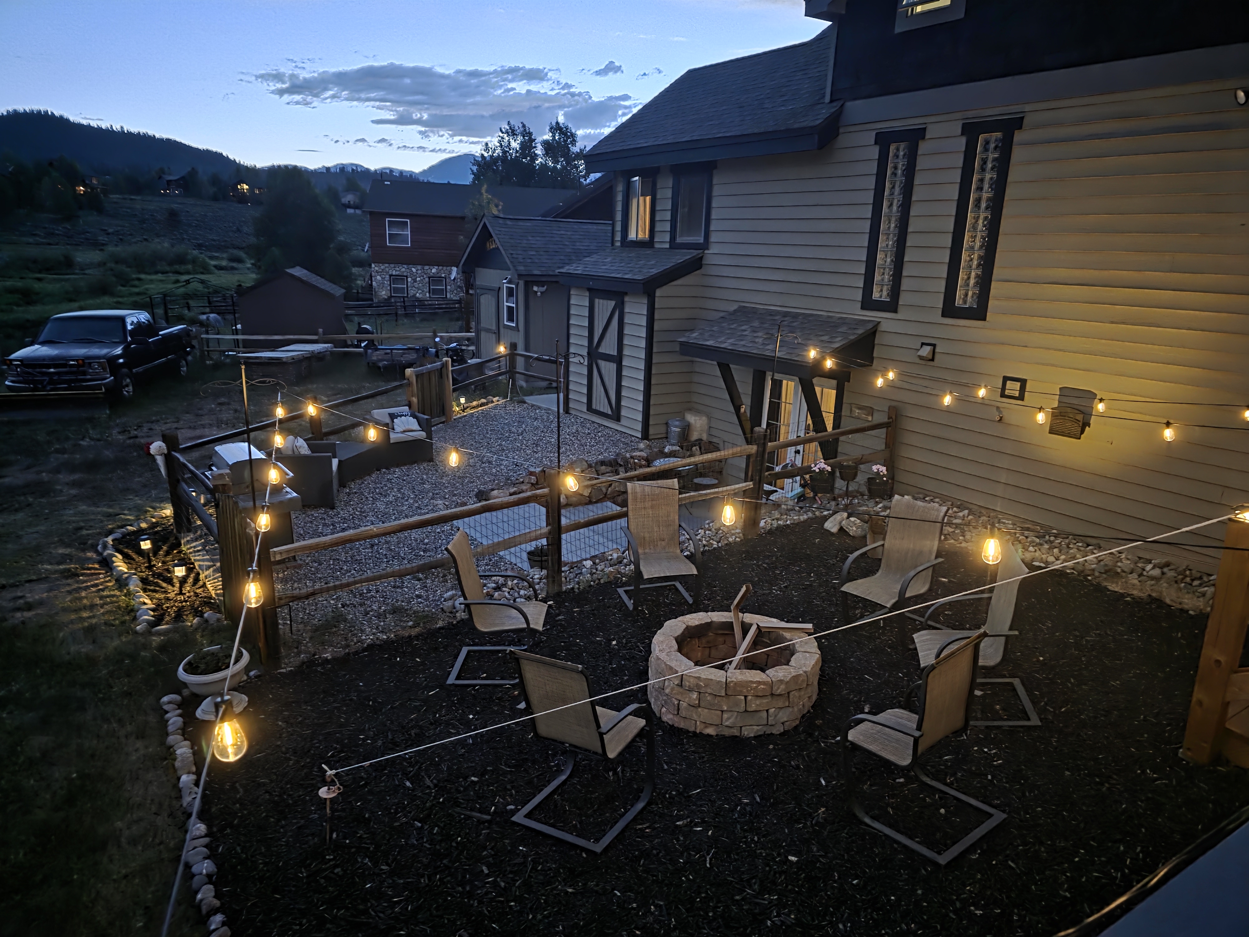Gas fire pit area with string lights at dusk
