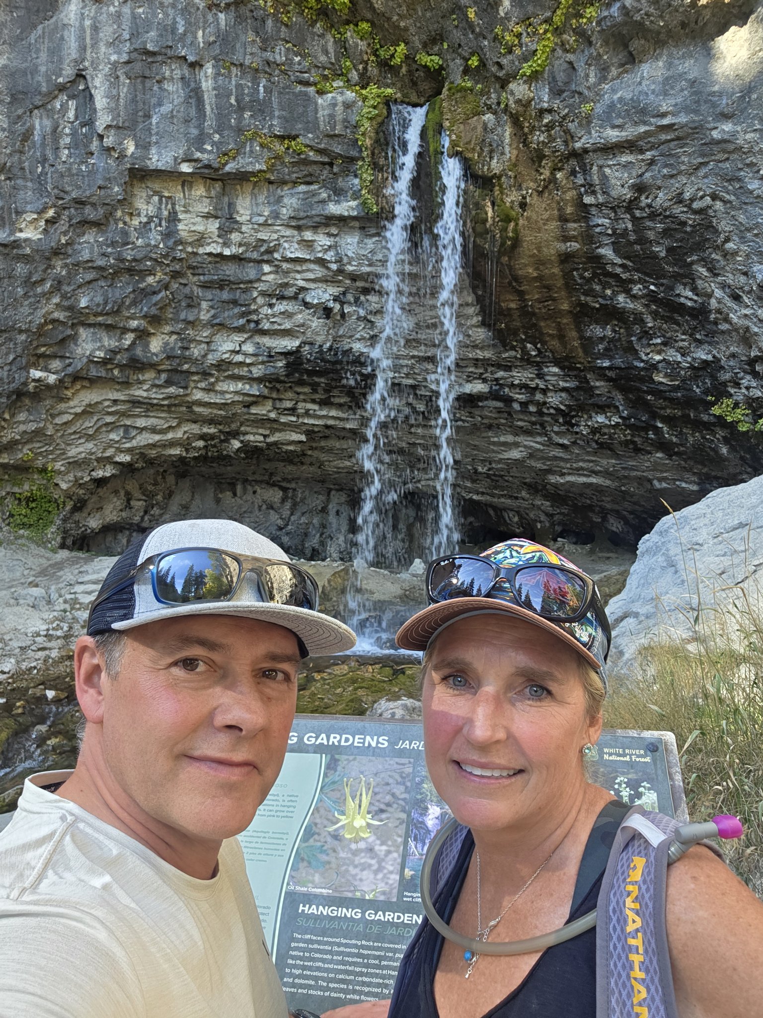 Shane and Michelle smiling in front of Spouting Rock waterfall at Hanging Lake