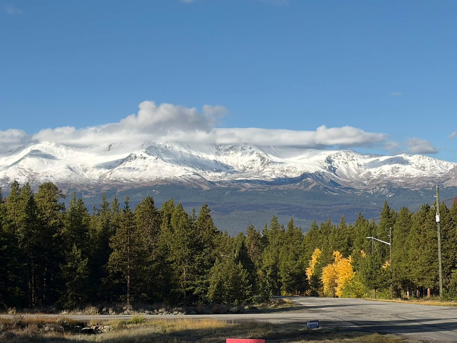 Snow-capped Collegiate Peaks under blue sky, photographed from the road in early October