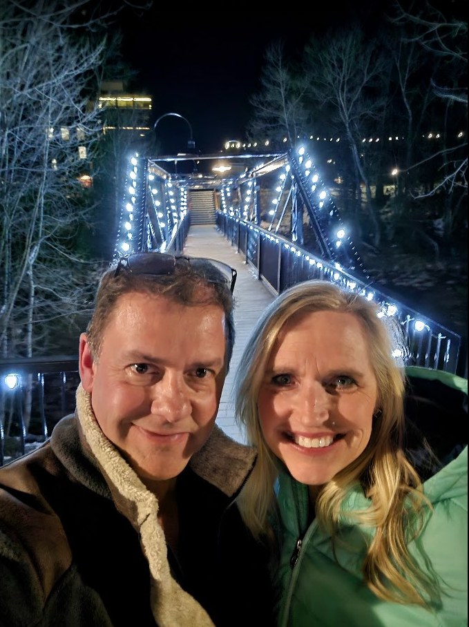 Shane and Michelle, your hosts, on a lit bridge in Breckenridge at night